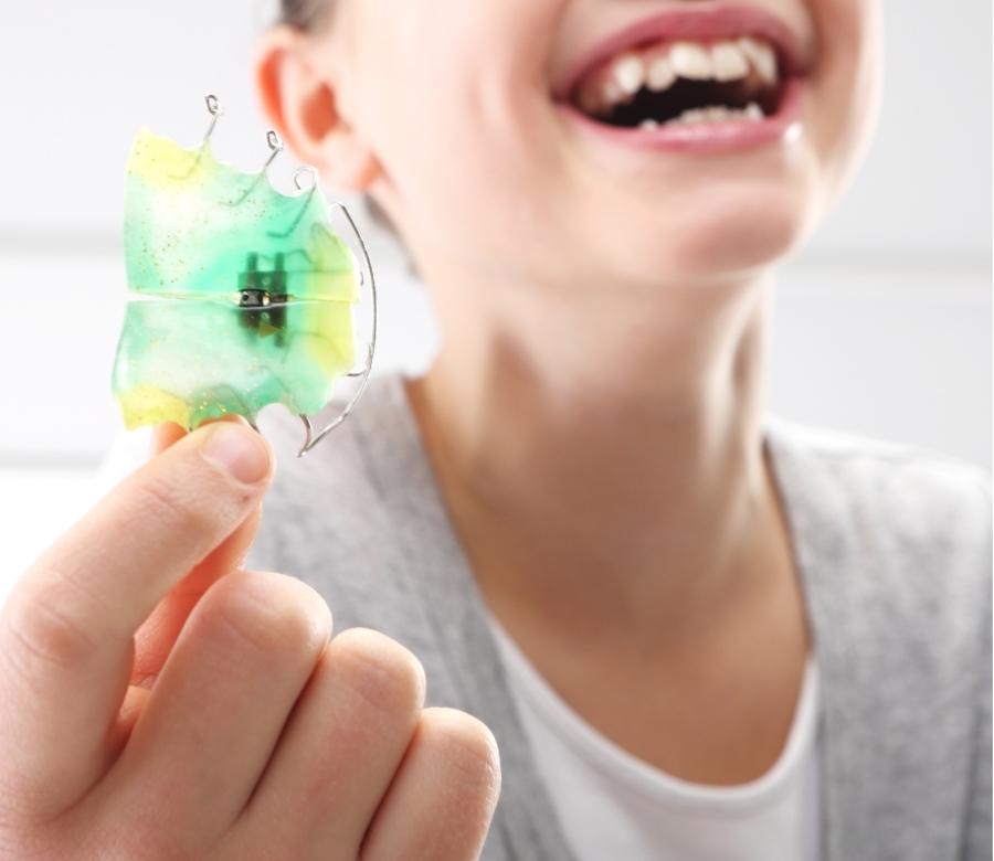 happy kid showing off her retainer 